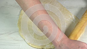 Process of homemade bake with wheat flour. The cook uses a rolling pin to stretch the dough. Chef cooks the food in the