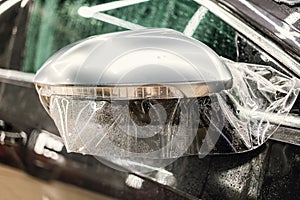 The process of installing PPF on the side mirror. Car wrapping.