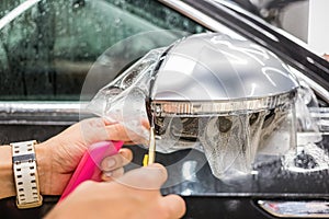 The process of installing PPF on the side mirror. Car wrapping.