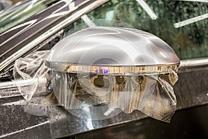 The process of installing PPF on the side mirror. Car wrapping.