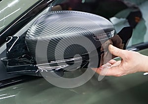 The process of installing PPF on the side mirror. Car wrapping close-up. Car wrapping.