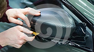 The process of installing PPF on the side mirror. Car wrapping close-up. Car wrapping.