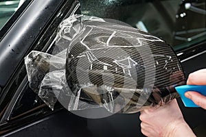 The process of installing PPF on the side mirror. Car wrapping close-up. Car wrapping.