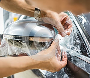 The process of installing PPF on the side mirror. Car wrapping.