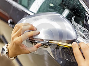 The process of installing PPF on the side mirror. Car wrapping.