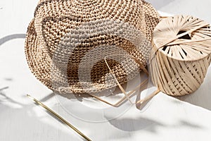 The process of knitting a raffia hat,