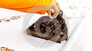 The process of making batik cloth. Batik is a type of cloth whose motifs are made manually