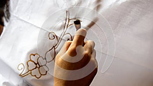 The process of making batik cloth. Batik is a type of cloth whose motifs are made manually