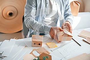 Process of making beautiful little wooden box. Print house worker in white clothes is indoors