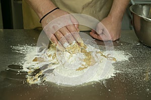 The process of making bread. The chef kneads the dough by hand. The hands of the chef mix all the ingredients for the dough