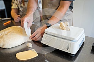 The process of making bread. Dividing the wheat dough into pieces for buns.