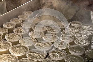 Process of making fresh white soft ricotta whey cheese on small cheese farm in Parma, Italy