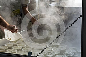 Process of making fresh white soft ricotta whey cheese on small cheese farm in Parma, Italy