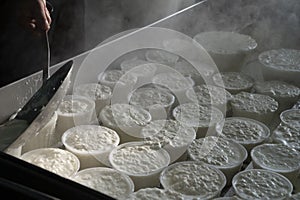 Process of making fresh white soft ricotta whey cheese on small cheese farm in Parma, Italy