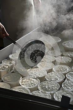 Process of making fresh white soft ricotta whey cheese on small cheese farm in Parma, Italy