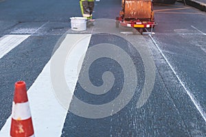 Process of making new road surface markings with a line striping machine, workers improve city infrastructure, demarcation marking
