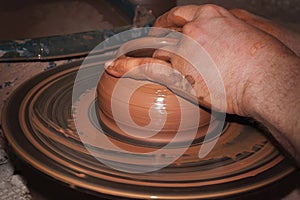 The process of making pottery. Craftsman`s hands. Work on a potter`s wheel