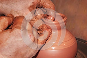 The process of making pottery. Craftsman`s hands. Work on a potter`s wheel