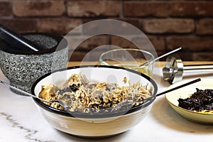 Process of making pulled pork with red ancho chili paste on a marble top kitchen counter