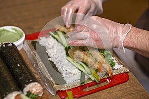 Process of making sushi and rolls. Close-up of man chef hands preparing traditional Japanese food at home or in restaurant on