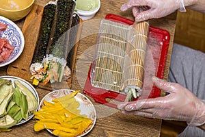 Process of making sushi and rolls. Close-up of man chef hands preparing traditional Japanese food at home or in restaurant on