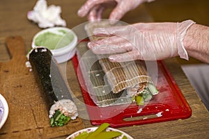 Process of making sushi and rolls. Close-up of man chef hands preparing traditional Japanese food at home or in restaurant on