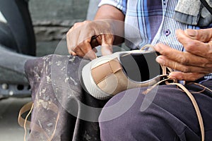 Process of manual shoe reparation, sole and welt fixing and stitching