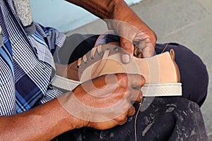 Process of manual shoe reparation, sole and welt fixing and stitching