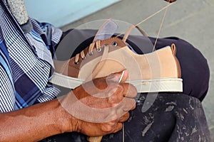 Process of manual shoe reparation, sole and welt fixing and stitching photo