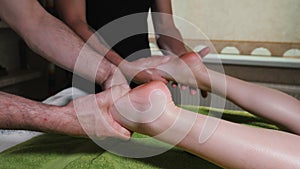 Process of masseur`s work with female client. Male therapist massaging woman`s feet. Body care, skin care, wellness