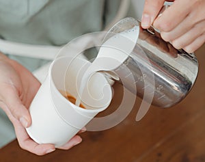 The process of mixing milk with coffee photo