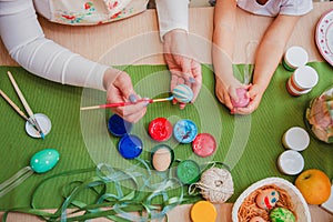 The process of painting eggs for Easter. In the frame, adults and children& x27;s hands. Top view.