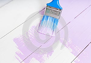 Process of painting the wood boards with brush and violet color