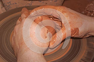 The process of pottery. Work on a potter`s wheel. The hands of the master form a product from a lump of clay