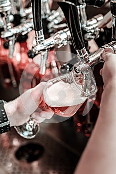 Process of pouring pale beer through a fount. photo