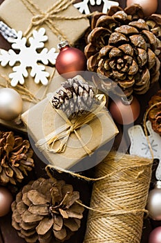 Process of praparing and wrapping Christmas and New Year gits, natural materials, craft paper, twine, pine cones, wood ornaments