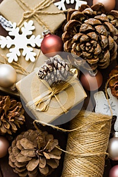 Process of praparing and wrapping Christmas and New Year gits, natural materials, craft paper, twine, pine cones, wood ornaments photo