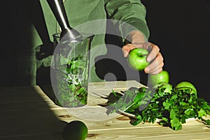 Process of preparing green detox smoothie with blender, young man hands cooking healthy smoothie with fresh fruits and greens spin