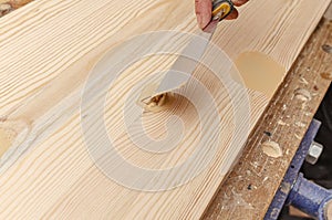 The process of puttying a wooden board. Spatula, putty, wooden board. Carpentry works