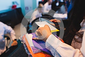 Process of receiving gift bag package for conference participants before start, with a leaflet handout, notebook notepad, t-shirt