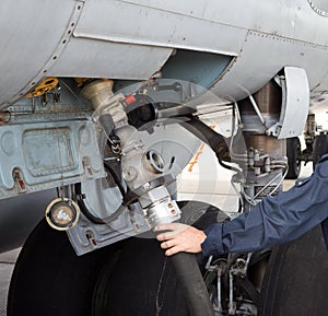 The process of refueling airplane in airport. Fuel hose is inserted