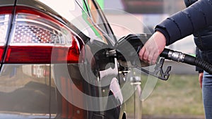 Process of refueling car fill with petrol fuel at the gas station, pump filling fuel nozzle in fuel tank of car, high