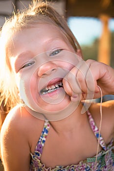 The process of removing a baby tooth using a thread