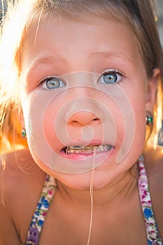 The process of removing a baby tooth using a thread