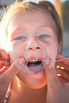 The process of removing a baby tooth using a thread