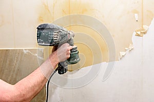 Process of removing old wallpaper. Cleaning wall from old wallpaper with water