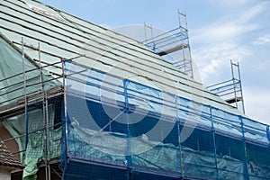 process of repair a house. Home construction.Construction and repair of the house.Scaffolding in a protective blue grid
