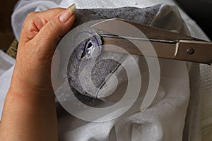The process of scissors cutting holes for eyelets curtains