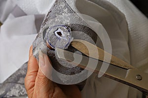 The process of scissors cutting holes for eyelets curtains