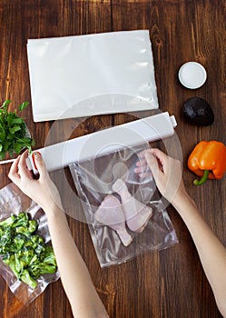 The process of sealing a vacuum bag with chicken legs with a vacuum cleaner